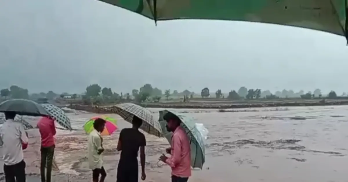 pregnant-woman-carried-on-cot-through-flooded-mp-road